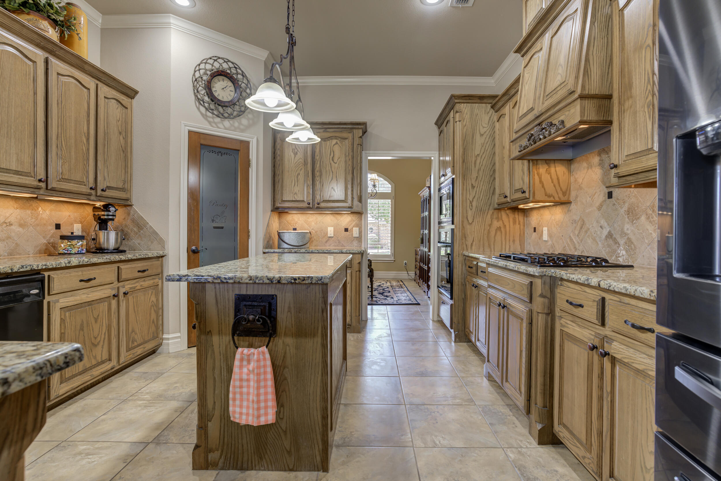 6008 89th Street Lubbock, TX 79424 - Photo 18 of 61 a kitchen with stainless steel appliances granite countertop a stove a sink and a refrigerator