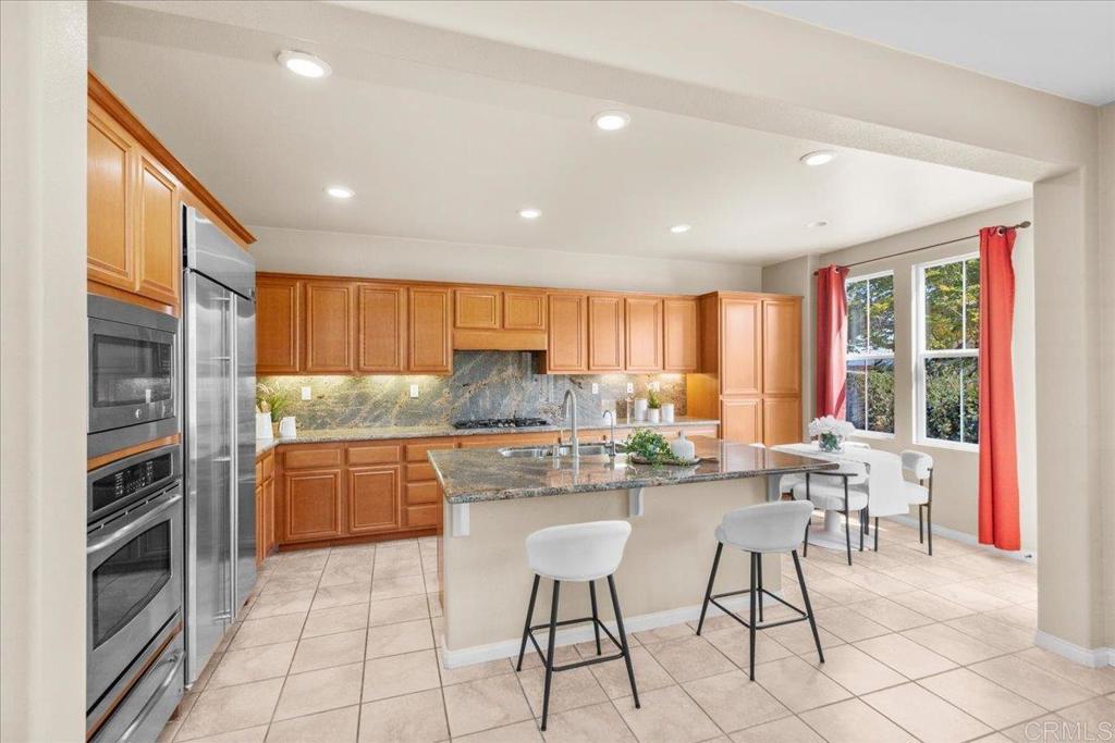 838 Luminara Way San Marcos, CA 92078 - Photo 26 of 54 a kitchen with stainless steel appliances granite countertop a stove top oven a sink dishwasher and a refrigerator