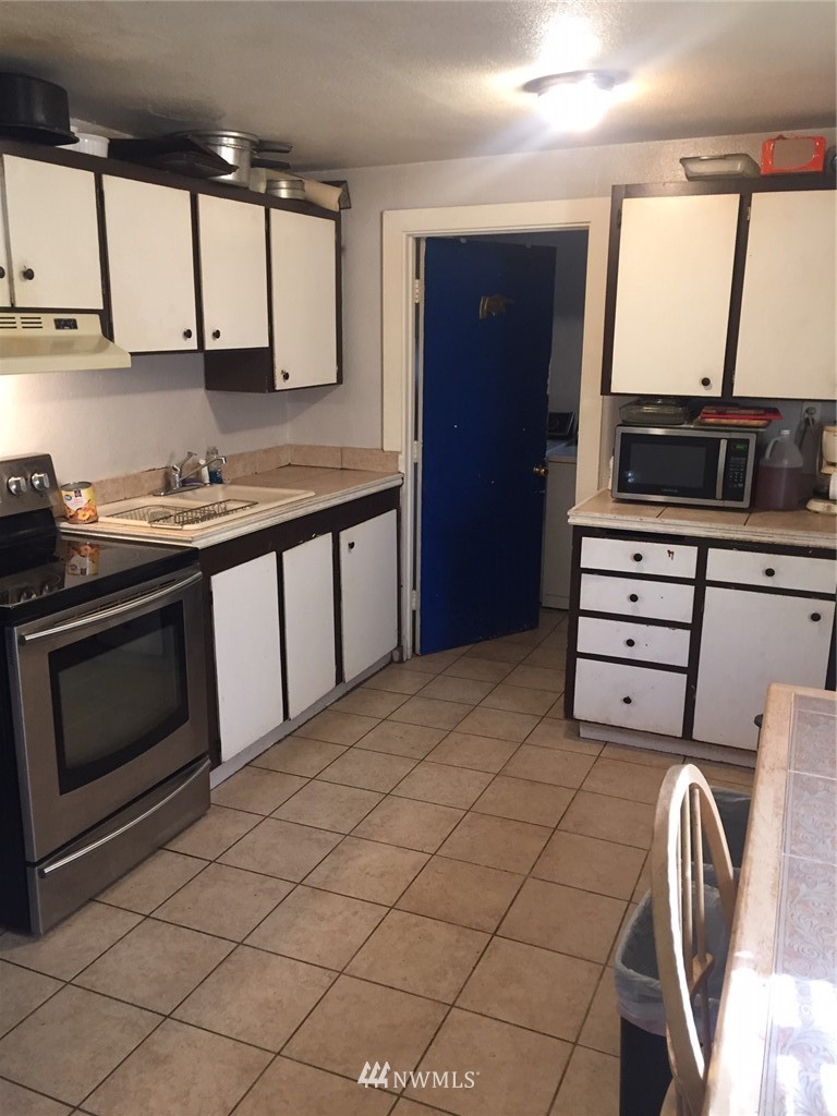 565 McNaught Road South, Unit 1&2 Roy, WA 98580 - Photo 11 of 14 a kitchen with stainless steel appliances granite countertop a sink and a stove