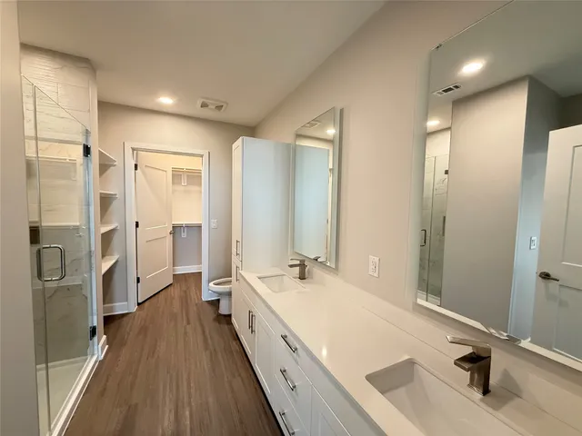 a bathroom with a double vanity sink a mirror and a shower