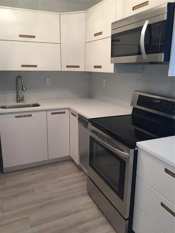 a kitchen with stainless steel appliances granite countertop a stove and a microwave