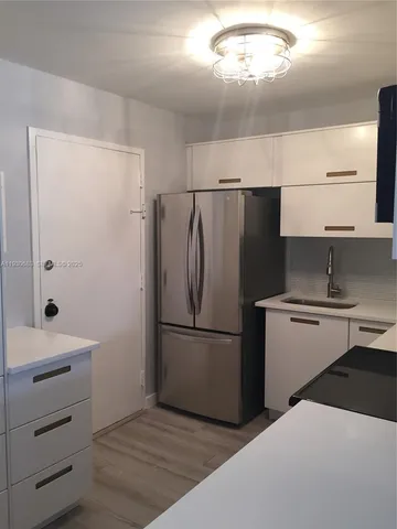 a kitchen with a refrigerator and a sink