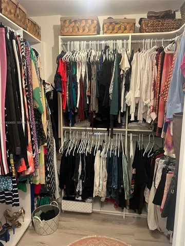 a view of walk in closet with clothes