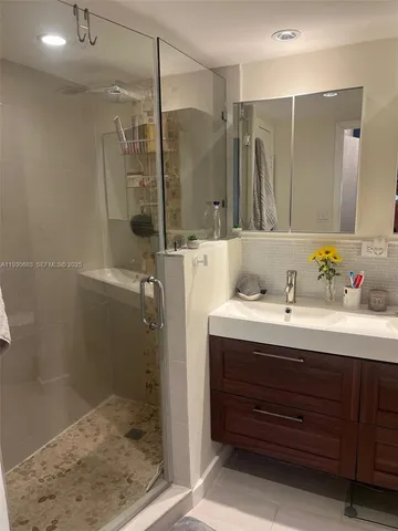 a bathroom with a shower sink and mirror