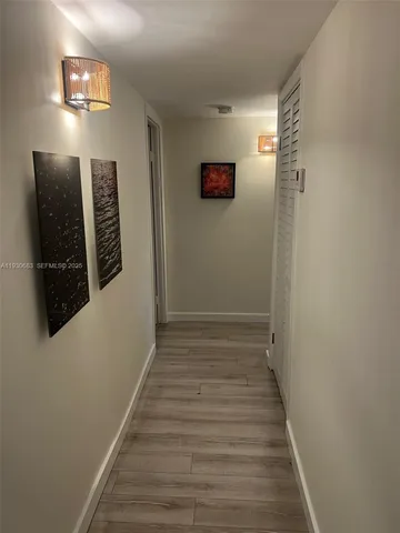 a view of a hallway with wooden floor and stairs