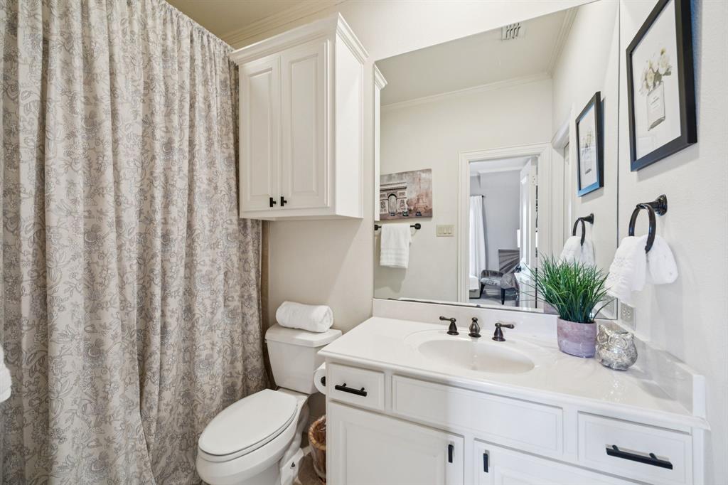4290 Castle Bank Lane Frisco, TX 75033 - Photo 34 of 40 a bathroom with a sink a toilet a mirror and shower curtain