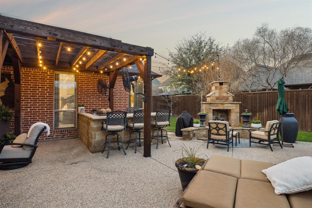 4290 Castle Bank Lane Frisco, TX 75033 - Photo 38 of 40 a living room with patio furniture and a fireplace