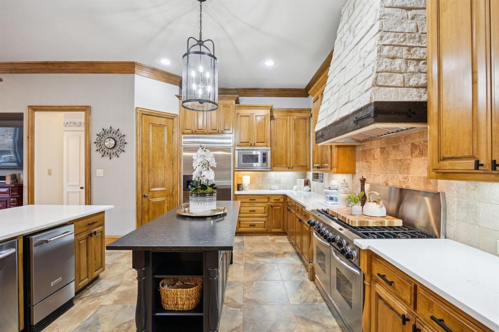 4290 Castle Bank Lane Frisco, TX 75033 - Photo 8 of 40 a kitchen with stainless steel appliances granite countertop a stove a sink dishwasher and a refrigerator with wooden floor