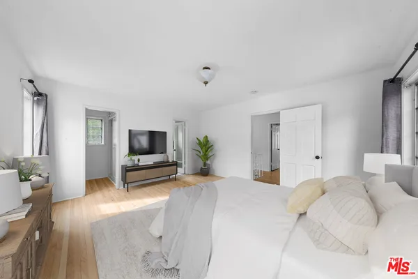 a bedroom with a bed and a flat screen tv