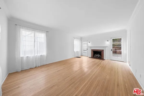 a view of empty room with wooden floor and fireplace