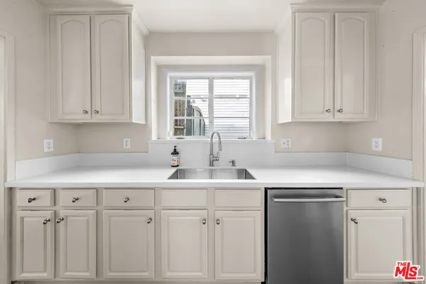 a kitchen with white cabinets and white appliances