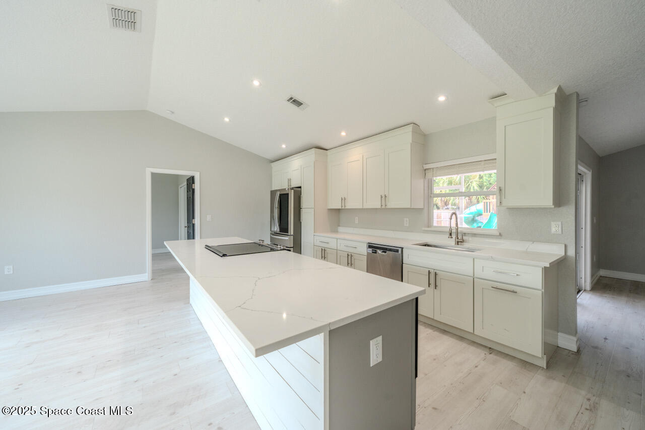 490 Tillman Avenue Southwest Palm Bay, FL 32908 - Photo 6 of 38 a large kitchen with a sink and white cabinets