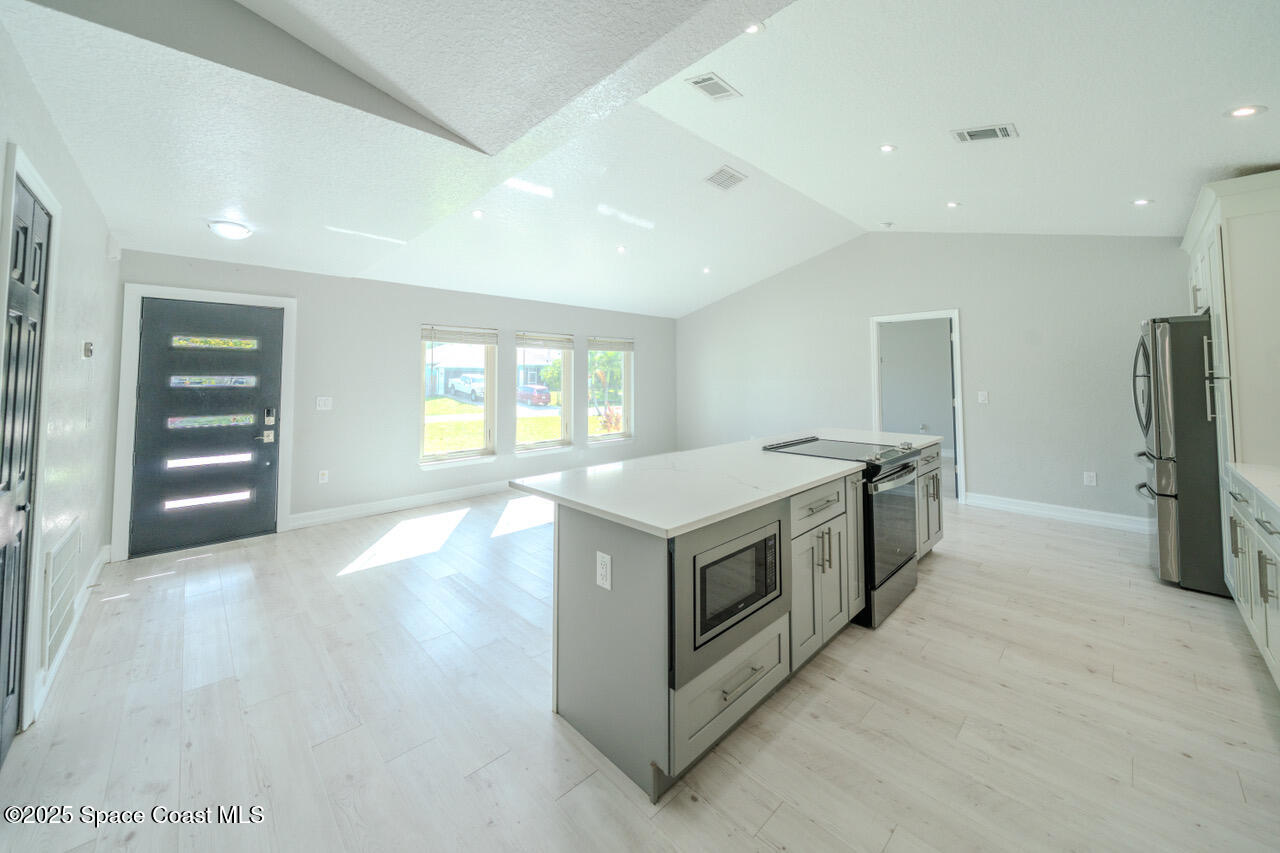 490 Tillman Avenue Southwest Palm Bay, FL 32908 - Photo 7 of 38 a view of kitchen with stainless steel appliances granite countertop a stove and a refrigerator