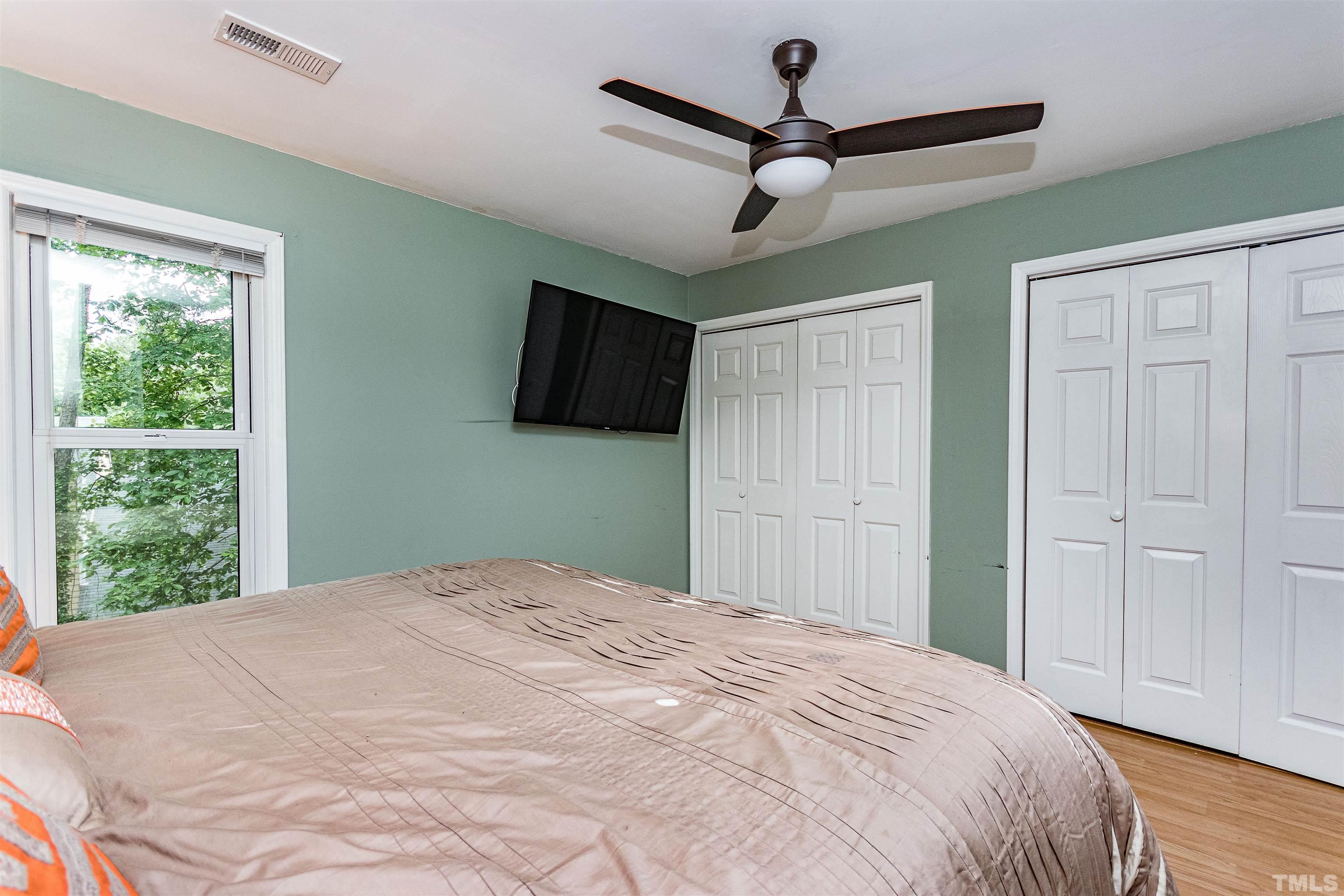 4517 Chinquoteague Court Raleigh, NC 27613 - Photo 22 of 26 a bedroom with a large bed and a flat tv screen