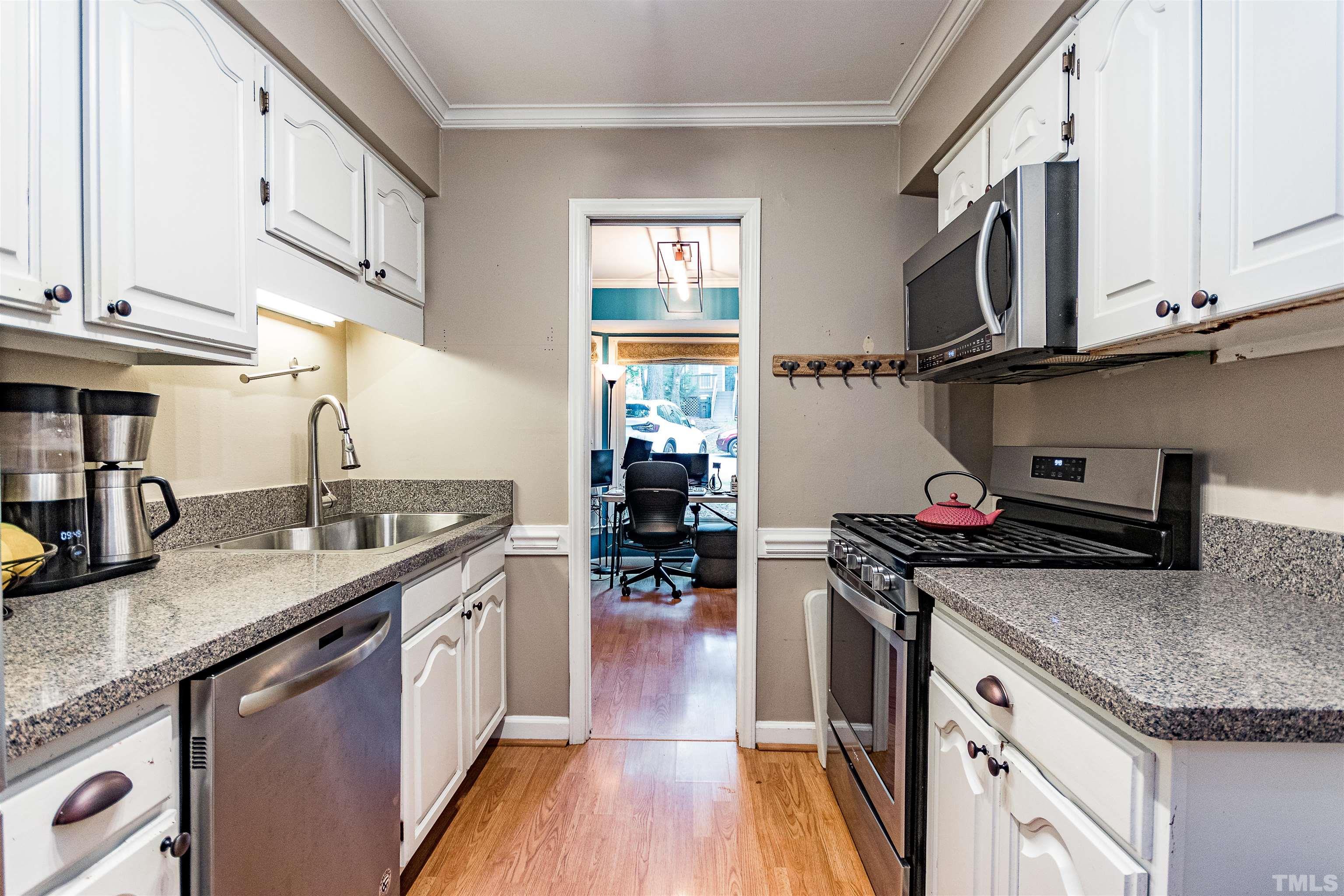 4517 Chinquoteague Court Raleigh, NC 27613 - Photo 6 of 26 a kitchen with stainless steel appliances granite countertop a sink stove and cabinets