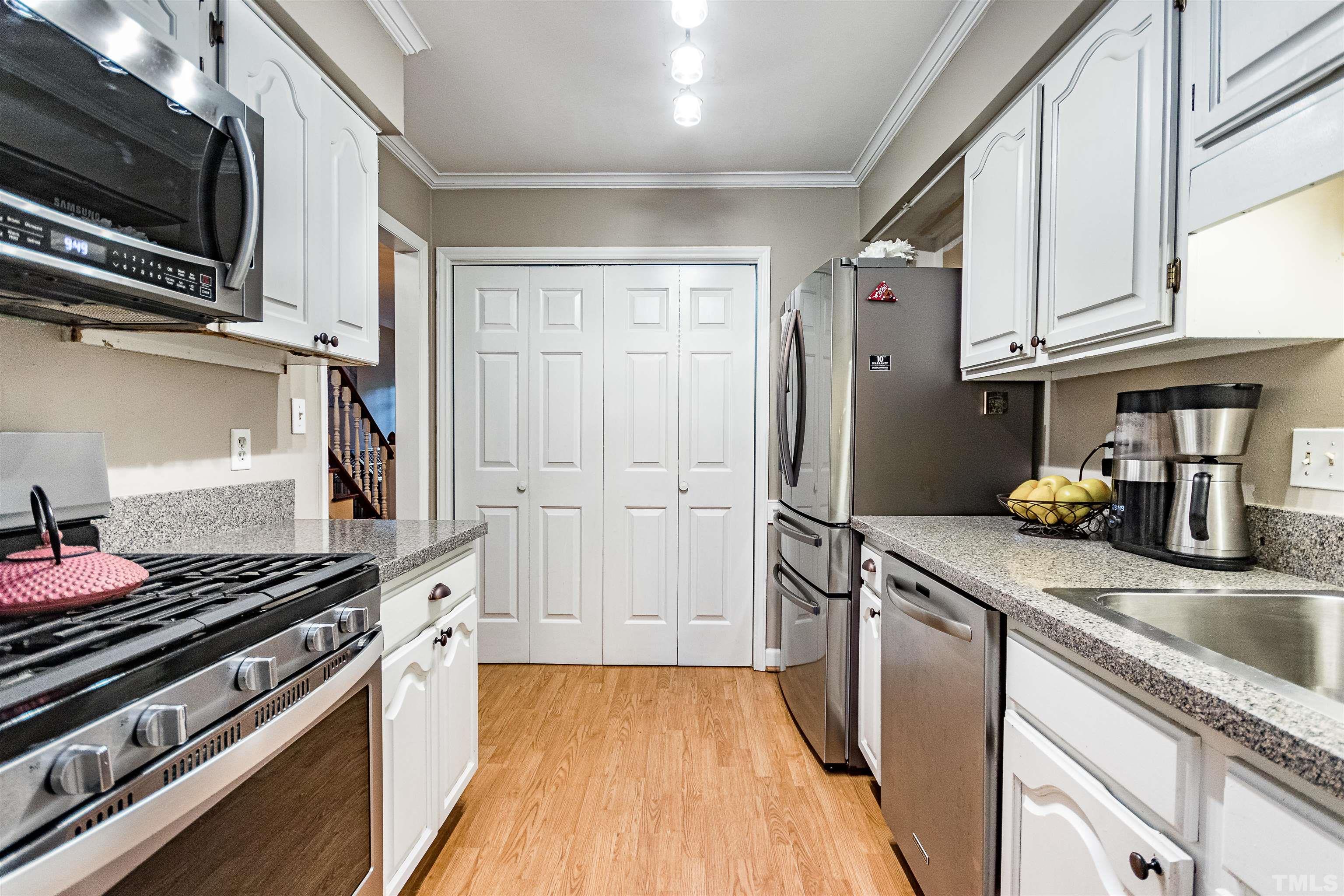 4517 Chinquoteague Court Raleigh, NC 27613 - Photo 8 of 26 a kitchen with stainless steel appliances granite countertop a stove and a refrigerator