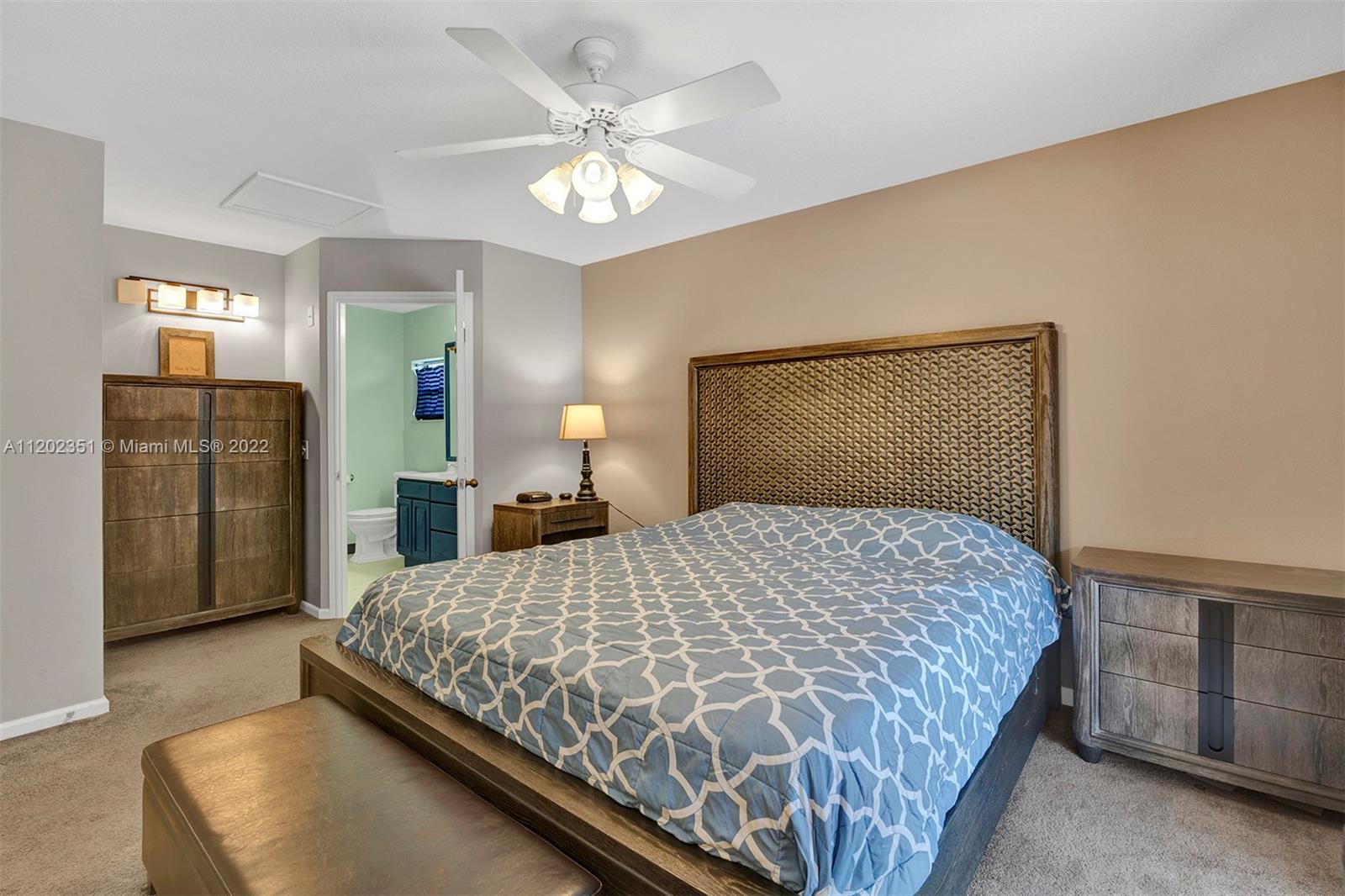 12801 Southwest 148th Street Road Miami, FL 33186 - Photo 11 of 39 a bedroom with a large bed and a chandelier