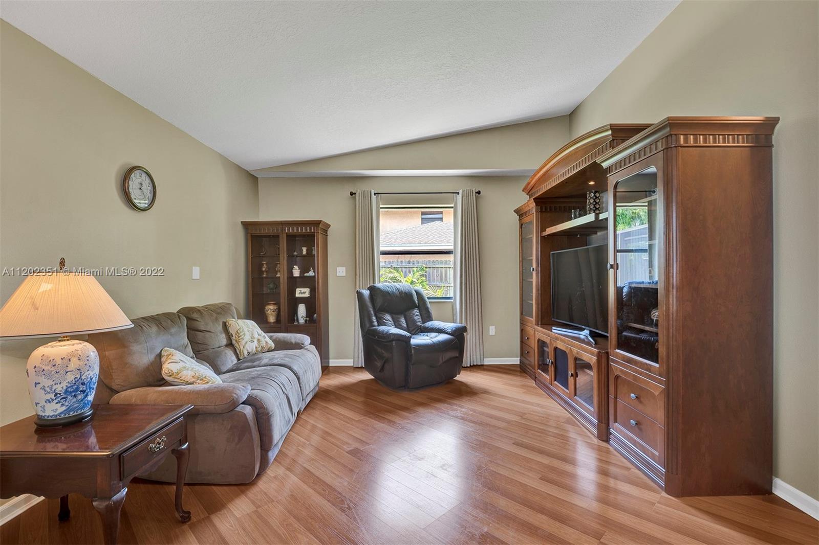 12801 Southwest 148th Street Road Miami, FL 33186 - Photo 22 of 39 a living room with furniture a flat screen tv and wooden floor