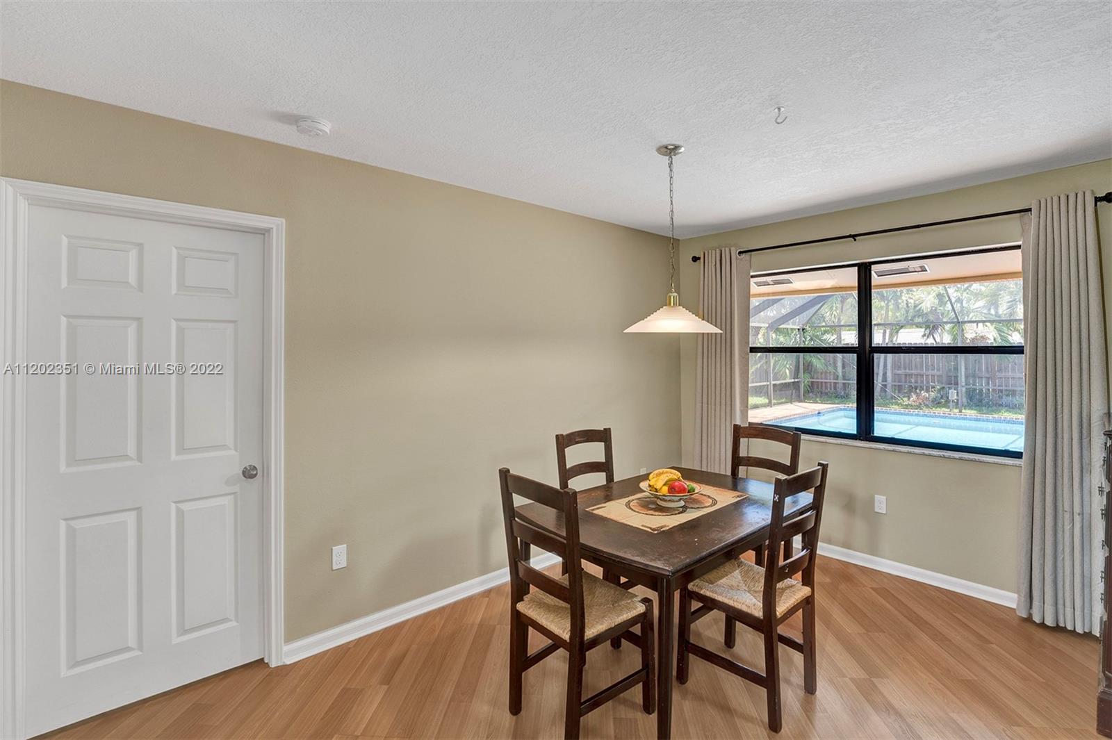 12801 Southwest 148th Street Road Miami, FL 33186 - Photo 26 of 39 a view of a dining room with furniture window and wooden floor