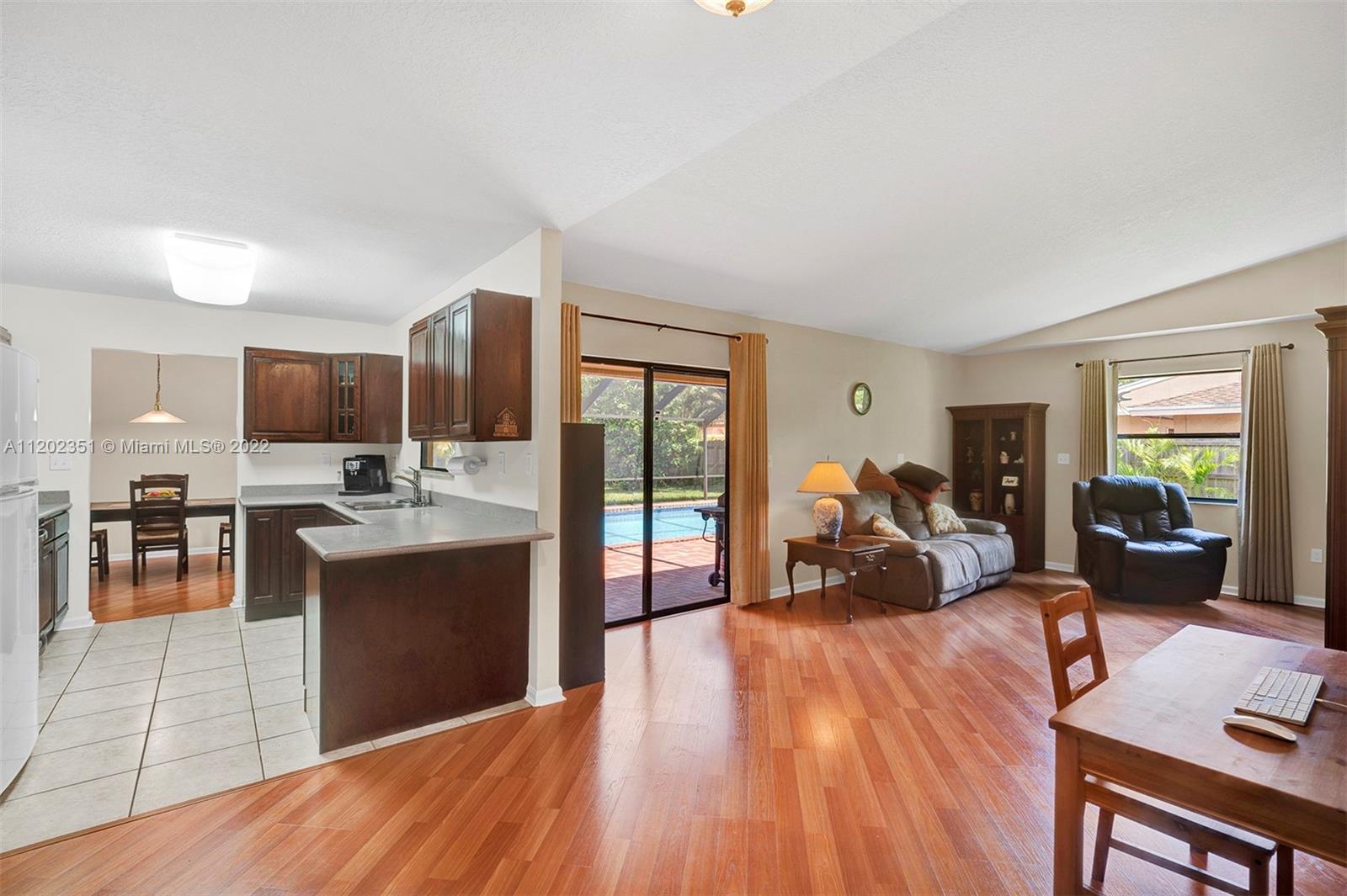 12801 Southwest 148th Street Road Miami, FL 33186 - Photo 4 of 39 a living room with stainless steel appliances granite countertop wooden floor a couch and a view of kitchen