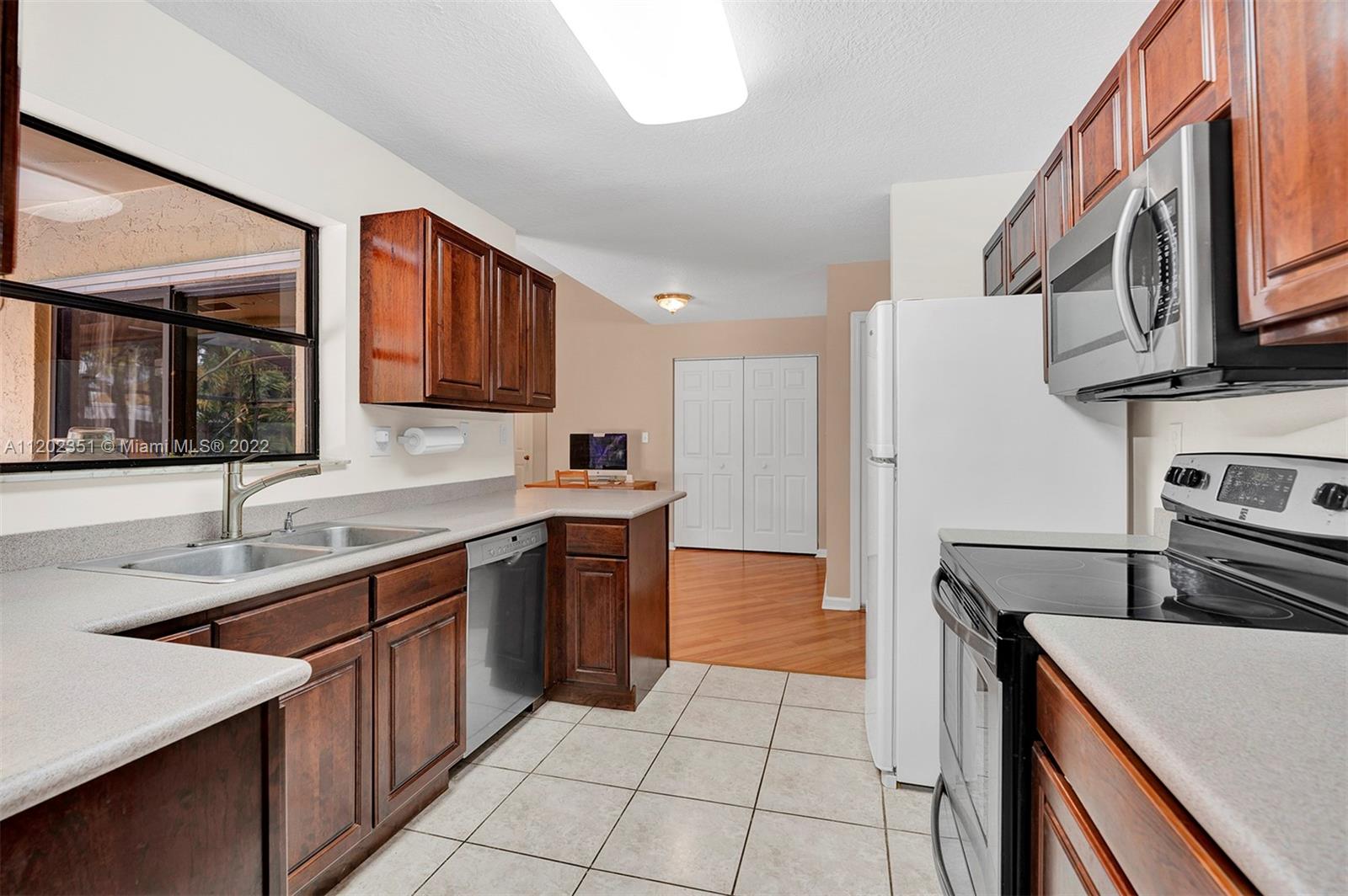 12801 Southwest 148th Street Road Miami, FL 33186 - Photo 6 of 39 a kitchen with stainless steel appliances granite countertop a sink stove and refrigerator