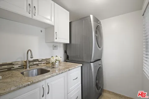 a kitchen with stainless steel appliances granite countertop a sink a refrigerator and a granite counter tops