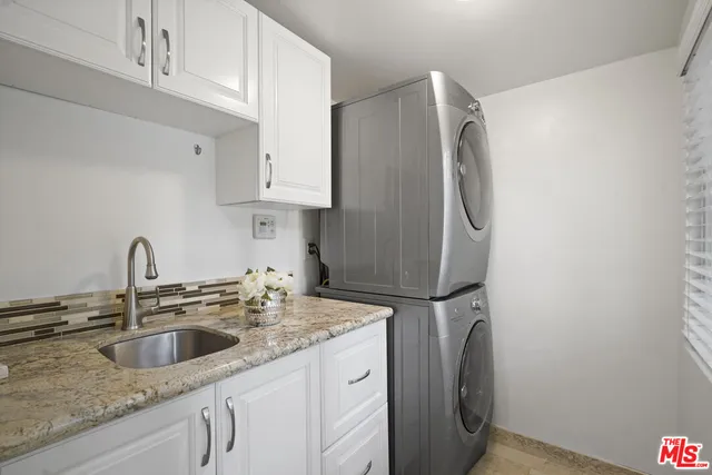 a kitchen with stainless steel appliances granite countertop a sink a refrigerator and a granite counter tops