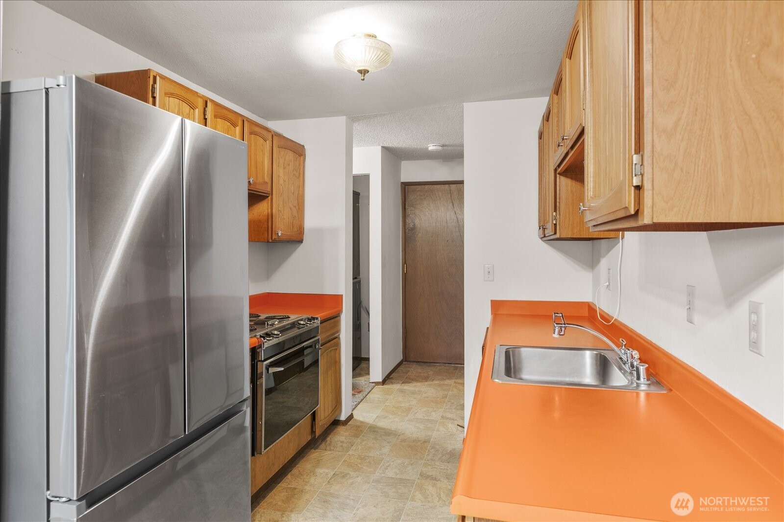 15914 3rd Place Southwest, Unit C Burien, WA 98166 - Photo 12 of 34 a kitchen with stainless steel appliances granite countertop a refrigerator and a stove