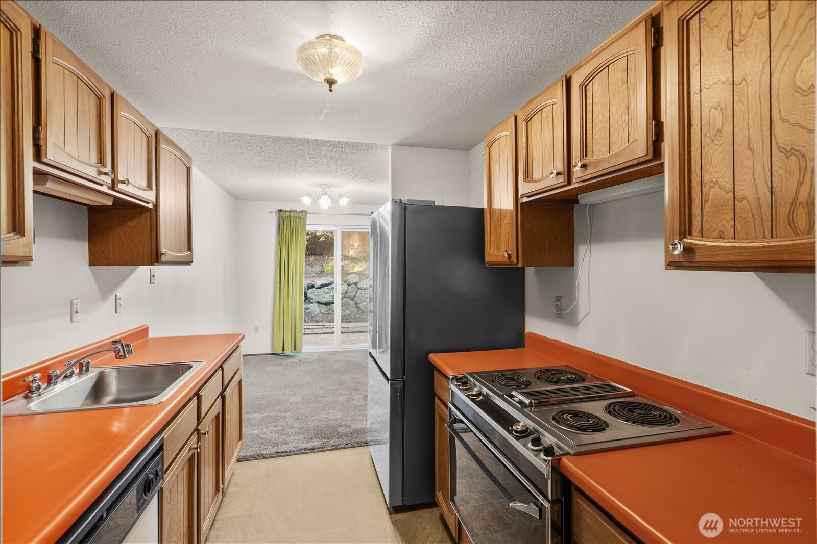 15914 3rd Place Southwest, Unit C Burien, WA 98166 - Photo 9 of 34 a kitchen with stainless steel appliances granite countertop a stove and a refrigerator