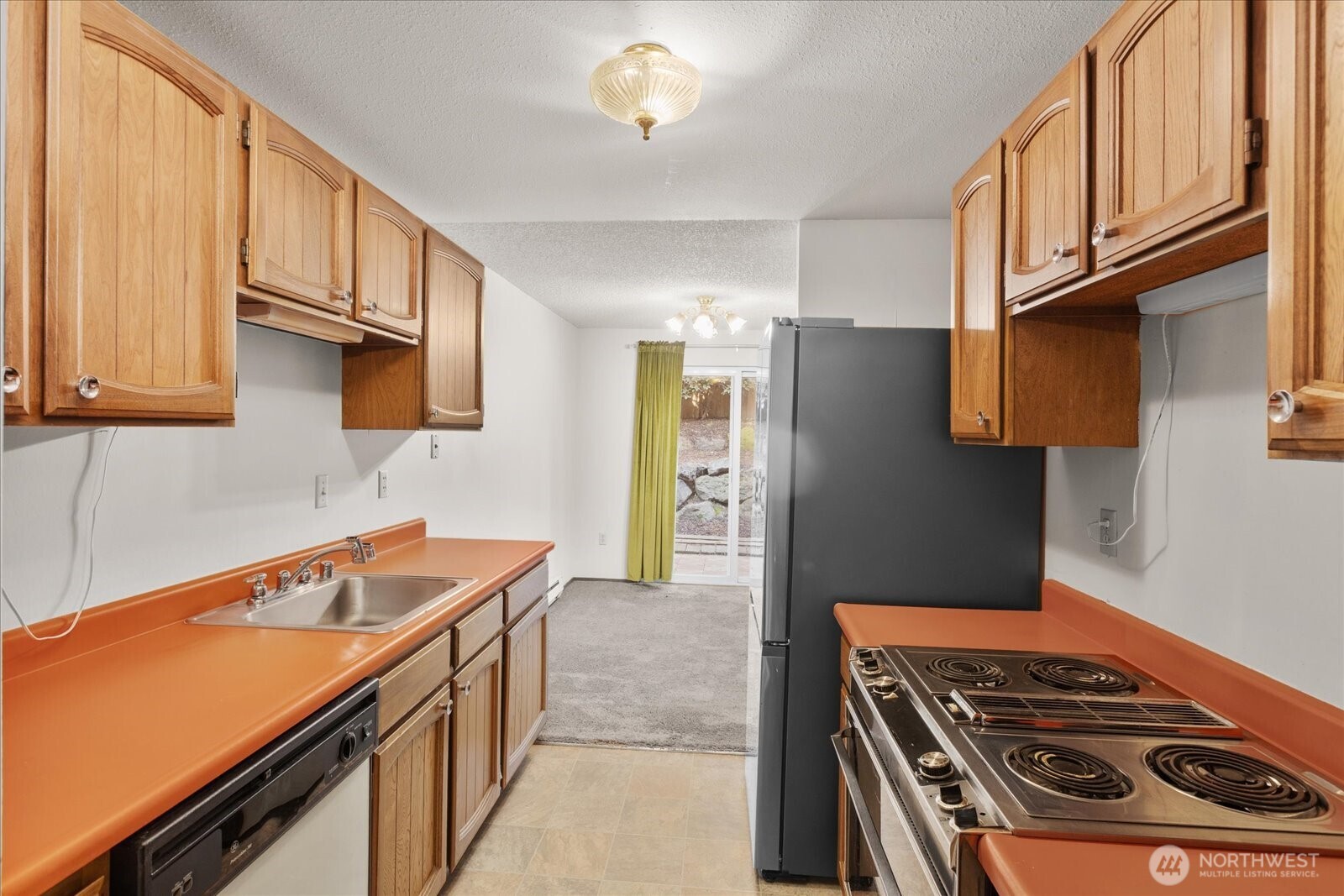 15914 3rd Place Southwest, Unit C Burien, WA 98166 - Photo 10 of 34 a kitchen with stainless steel appliances granite countertop a stove and a refrigerator