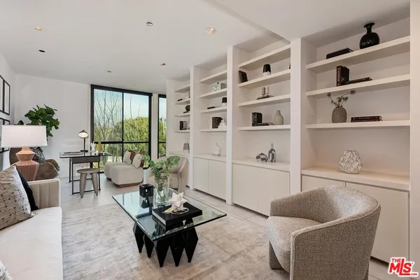 a living room with furniture cabinets and a window