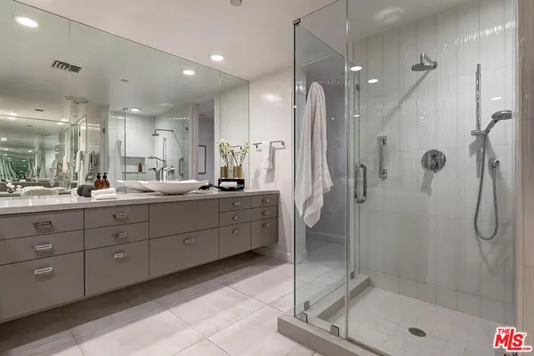 a bathroom with a double vanity sink mirror and shower
