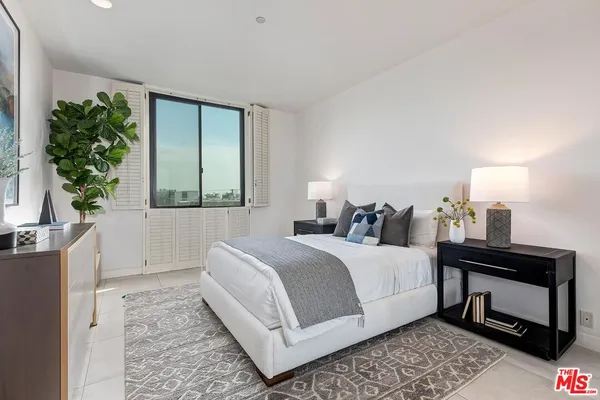 a bedroom with a bed and a potted plant