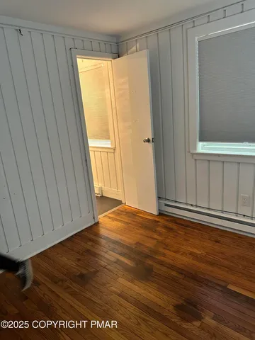 a view of empty room with wooden floor