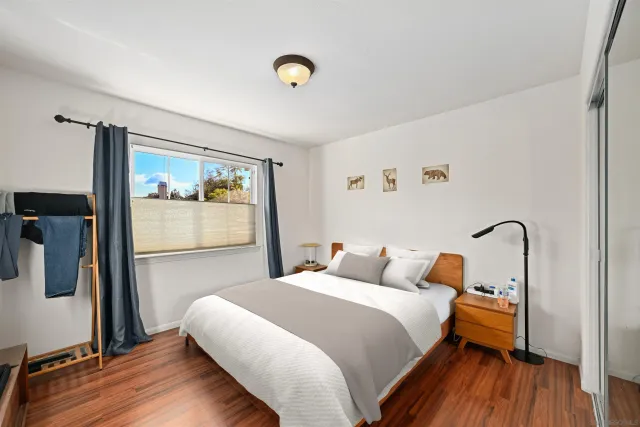 a bedroom with bed and wooden floor