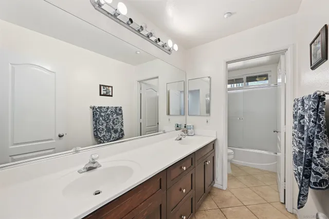 a spacious bathroom with a shower sink and mirror