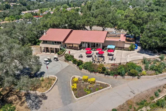 an aerial view of a house with swimming pool and outdoor seating