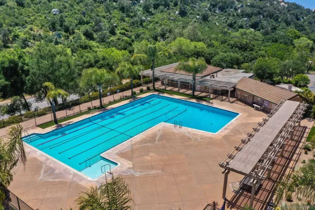a view of a swimming pool with lawn chairs under an umbrella