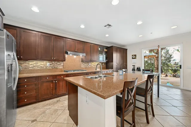 a kitchen with granite countertop sink cabinets dining table and chairs
