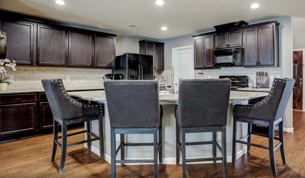 1 Rodeo Bend Drive Manvel, TX 77578 - Photo 7 of 22 a kitchen with stainless steel appliances kitchen island granite countertop a table chairs microwave and sink