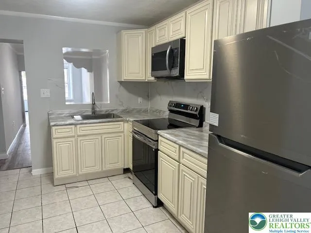 a stove top oven sitting inside of a kitchen