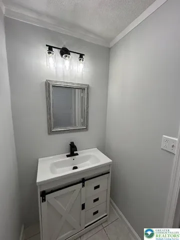 an empty room with a chandelier fan and windows