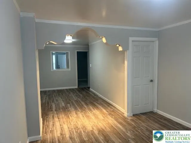 a view of empty room with window and wooden floor