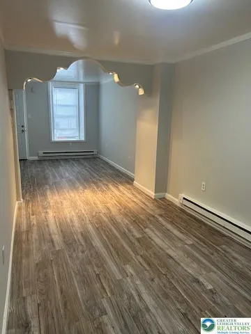 a view of a room with wooden floor and a window