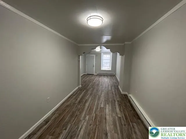 a view of a livingroom with wooden floor and a window