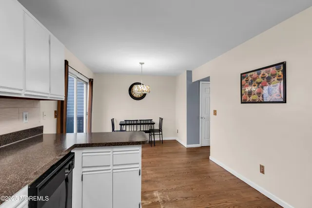a kitchen with granite countertop a stove and a wooden floors