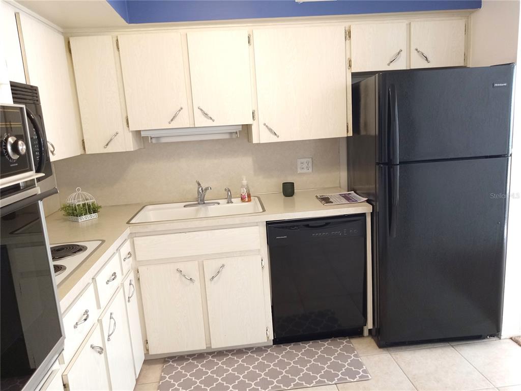2427 Rhodesian Drive, Unit 11 Clearwater, FL 33763 - Photo 6 of 44 a kitchen with a sink refrigerator and cabinets