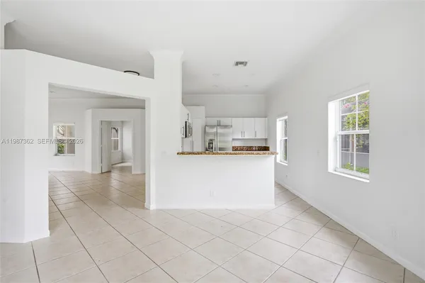 a view of a kitchen with kitchen island and wooden cabinets