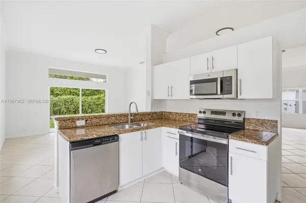 a kitchen with granite countertop a sink and a window