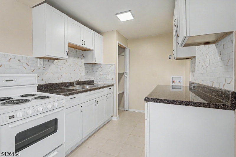 10 Berton Road Boonton, NJ 07005 - Photo 7 of 20 a kitchen with granite countertop a sink stove and white cabinets